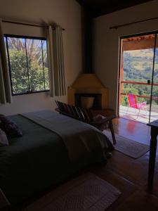 a bedroom with a bed and a window and a chair at Pousada Pedra Grande in Bueno Brandão