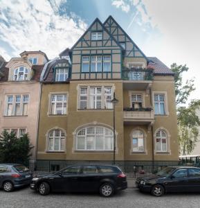 a building with cars parked in front of it at Due Passi Apartamenty w Sopocie in Sopot