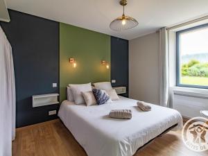 a bedroom with a large bed with a green wall at Gîte paisible au cœur des vignobles avec jardin et parking privatif - FR-1-622-3 in Rochefort-sur-Loire