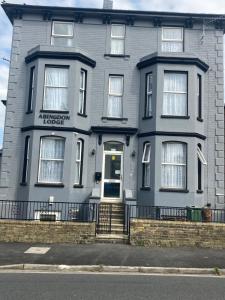 a blue house with a sign on the front of it at Abingdon Lodge & Suit in Ryde