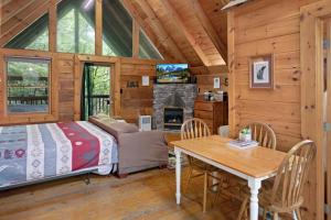 - une chambre et une salle à manger avec un lit et une table dans l'établissement Cozy Cabin! Hot Tub, King Bed, Fireplace, & Pool, à Gatlinburg