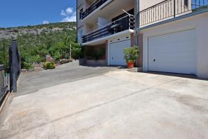a large driveway with two garage doors on a building at Apartments by the sea Senj - 22576 in Senj