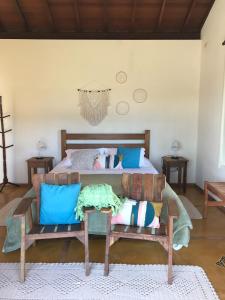 a bedroom with a bed and two chairs at Pousada Pedra Grande in Bueno Brandão