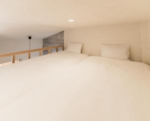 a bedroom with two beds with white sheets at Flower Base Lily House - Vacation STAY 57830v in Fukuoka
