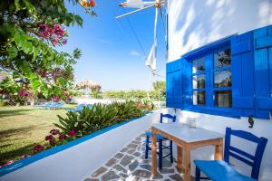 a blue table and chairs on a porch with a yard at Anemomilos Studios in Gerani
