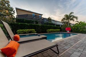 una piscina con un banco y una casa en Lovely Disney-Themed Family Retreat Pool Theater en Orlando