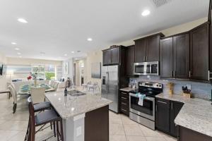 a kitchen with black cabinets and a kitchen with a table at Lovely Disney-Themed Family Retreat Pool Theater in Orlando