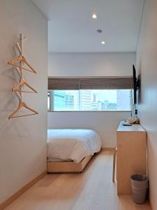 1 dormitorio con cama y ventana en Gloryinn, en Seúl