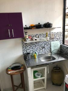 uma pequena cozinha com um balcão e um lavatório em La Playa Hospedagem em João Pessoa