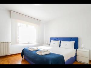 sypialnia z niebiesko-białym łóżkiem i oknem w obiekcie PortoHouse w Porto