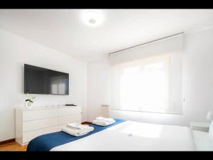 Un dormitorio blanco con una cama con toallas. en PortoHouse, en Oporto