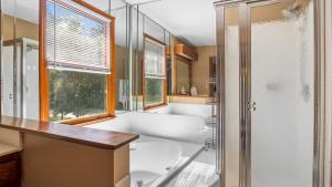 a bathroom with a tub and a sink and a shower at 4bd Contemporary Home with BBQ, Game Room in Charlotte +32 photos