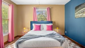 a bedroom with a bed with pink and blue walls at 4bd Contemporary Home with BBQ, Game Room in Charlotte