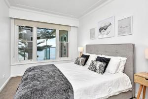 Un dormitorio blanco con una cama grande y una ventana. en Filoli, en Salamander Bay