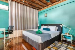 1 dormitorio con 1 cama grande y paredes azules en On Nut Nomad Homestay, en Bang Chak