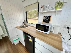 a kitchen with a counter with a microwave and a sink at Avondale Heights 
