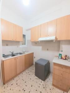 an empty kitchen with wooden cabinets and a sink at A-Apartments -- Agiou Therapontos in Athens