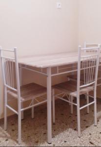 un tavolo e due sedie seduti accanto a un tavolo di A-Apartments -- Agiou Therapontos ad Atene