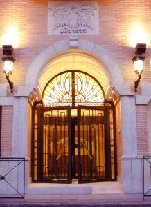 マドリードにあるホテル ドン ルイスの大きな扉付きの建物の入口