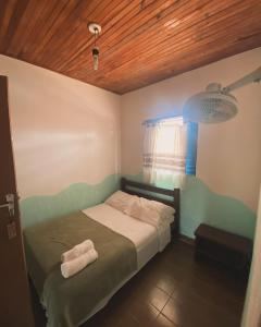 1 dormitorio con 1 cama con 2 toallas en Hospedaria São Jorge - Chapada dos Veadeiros en Sao Jorge