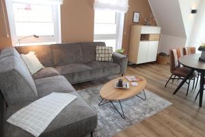 a living room with a couch and a table at Kleine Auszeit 23 in Greetsiel