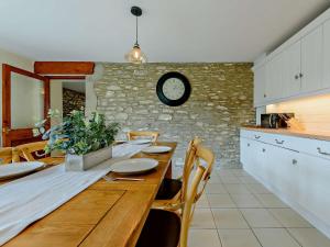 a kitchen with a wooden table and a clock on the wall at 3 Bed in New Quay LLWYD in Pencader
