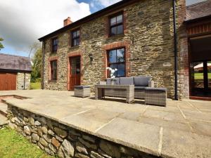 a stone patio in front of a stone house at 3 Bed in New Quay LLWYD in Pencader