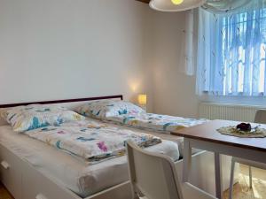 1 dormitorio con 2 camas, mesa y mesa en Ferienwohnung Uschis Sommergarten - Gartenidyll im Allgäu, en Wangen im Allgäu