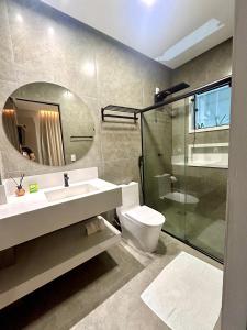 a bathroom with a sink and a toilet and a mirror at Pousada Rainha Dos Lagos in Capitólio