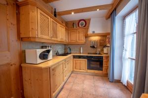 a kitchen with wooden cabinets and a white microwave at Haus 34 Top 1 in Krimml