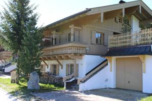 a large house with a balcony and a tree at Haus 34 Top 1 in Krimml