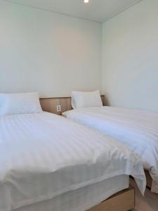 Duas camas sentadas uma ao lado da outra num quarto em Gloryinn em Seul