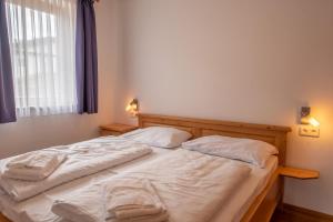 een slaapkamer met twee bedden met witte lakens en een raam bij Duxeranger D Top 2 in Krimml