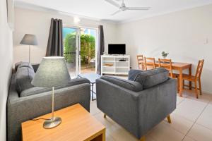 Sala de estar con 2 sofás y mesa en Arlia Sands Apartments, en Hervey Bay