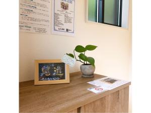 uma planta sentada em cima de uma mesa com uma imagem em Sunset Village - Vacation STAY 15314v em Onomichi