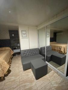 a room with two beds and a couch and a mirror at Hotel La Romana Center in La Romana