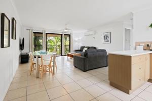 cocina y sala de estar con mesa y sillas en Arlia Sands Apartments, en Hervey Bay