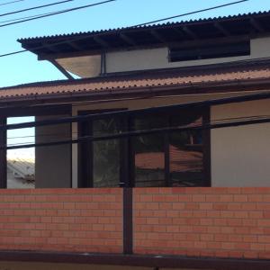 una ventana de una casa con una pared de ladrillo en Nascer Do Sol Suites, en Guarda do Embaú