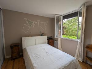 1 dormitorio con cama blanca y ventana en Appartement Arcachon, 2 pièces, 4 personnes - FR-1-420-134, en Arcachon