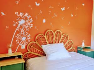ein Schlafzimmer mit einer orangefarbenen Wand mit einem Bett und Schmetterlingen in der Unterkunft Appartement Confort pour 4 au Centre de Mimizan – Plage, Lac, et Activités à Proximité - FR-1-50-119 in Mimizan