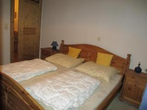 een slaapkamer met een houten bed met gele kussens bij Haus Sonnbichl Top 3 in Krimml