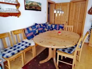 een houten tafel en stoelen in een kamer met een bank bij Haus 129 Top 1 in Krimml