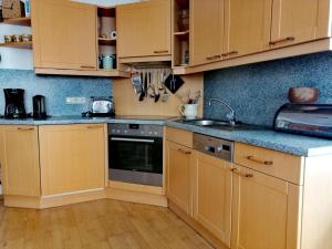 een keuken met houten kasten, een wastafel en een fornuis bij Haus 129 Top 1 in Krimml