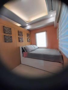 Habitación pequeña con cama y ventana en 1 BR SMDC North Edsa Condo with Balcony & Netflix, en Manila