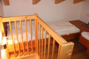 a bedroom with a bed and a wooden crib at Haus Amelie Top 2 in Krimml +4 photos
