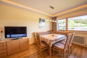 Un comedor con una mesa y un televisor. en Haus Elisabeth Top 116, en Krimml