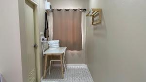 ein Bad mit einer Dusche mit einem Stuhl und einem Waschbecken in der Unterkunft Juni House Chumphon in Chumphon