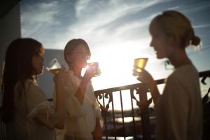 Jacuzzi Terrace Okinawa IMS في موتوبو: مجموعة من الناس يشربون النبيذ على الشرفة