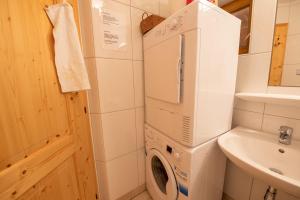 a washing machine in a bathroom next to a sink at Almhäuser Filzsteinalpe Almhaus 198 in Krimml
