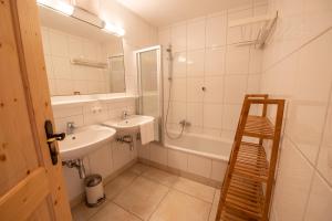 a bathroom with a sink and a mirror and a tub at Almhäuser Filzsteinalpe Almhaus 198 in Krimml +5 photos